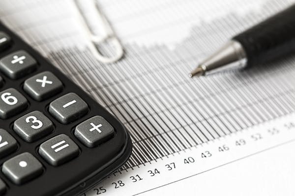Financement des organismes communautaire : calculatrice et stylo sur une feuille représentant un graphique