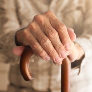 2 mains d'une personne âgée sur une canne