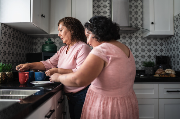 Une mère aide sa fille en situation de handicap dans la cuisine